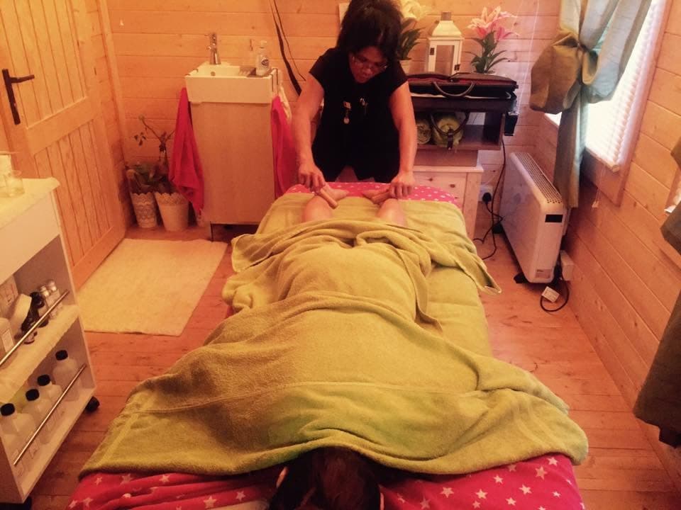 Firm, deep massage work with warm bamboo in the log cabin studio