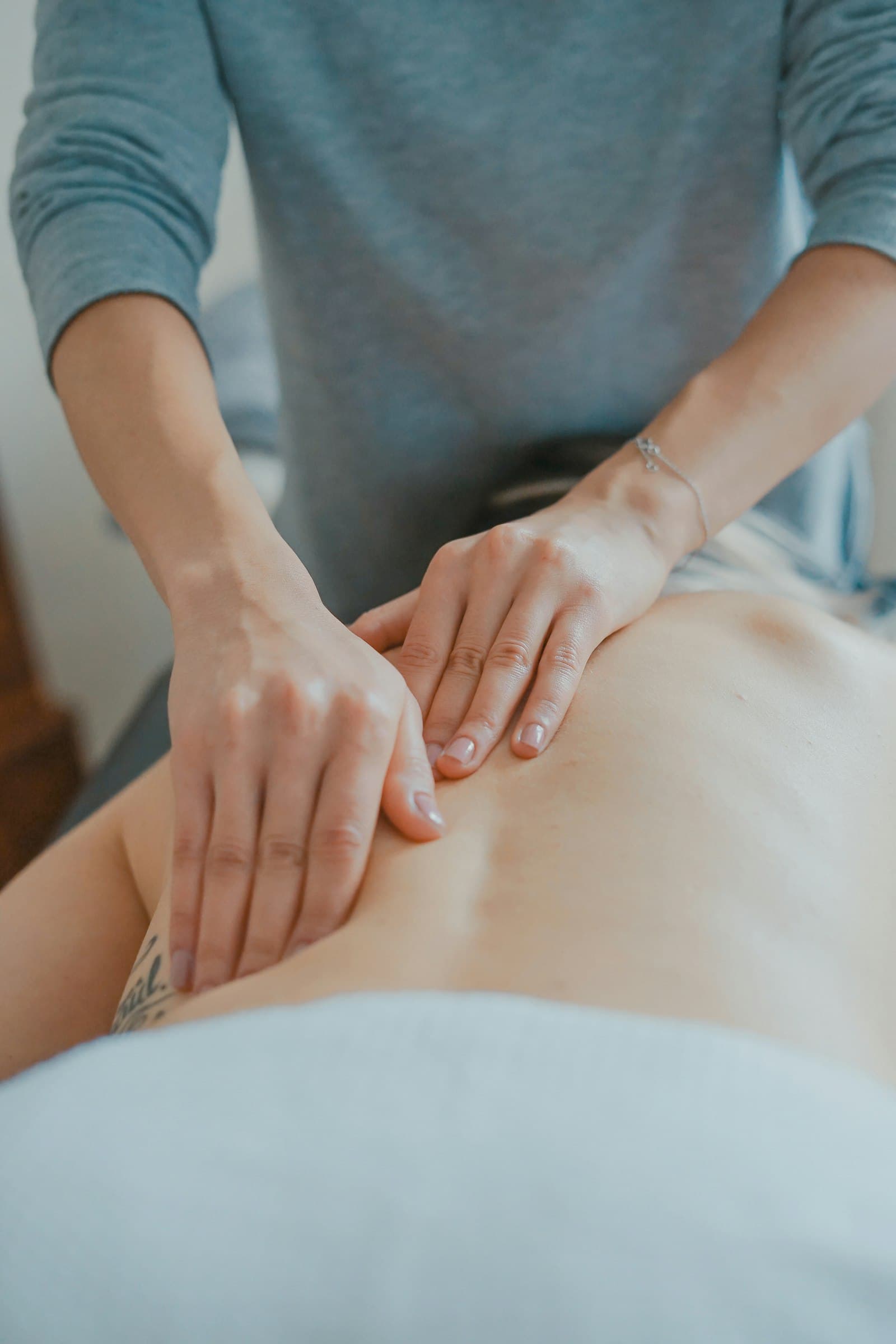 Calm hands working slowly along the back muscles during a massage