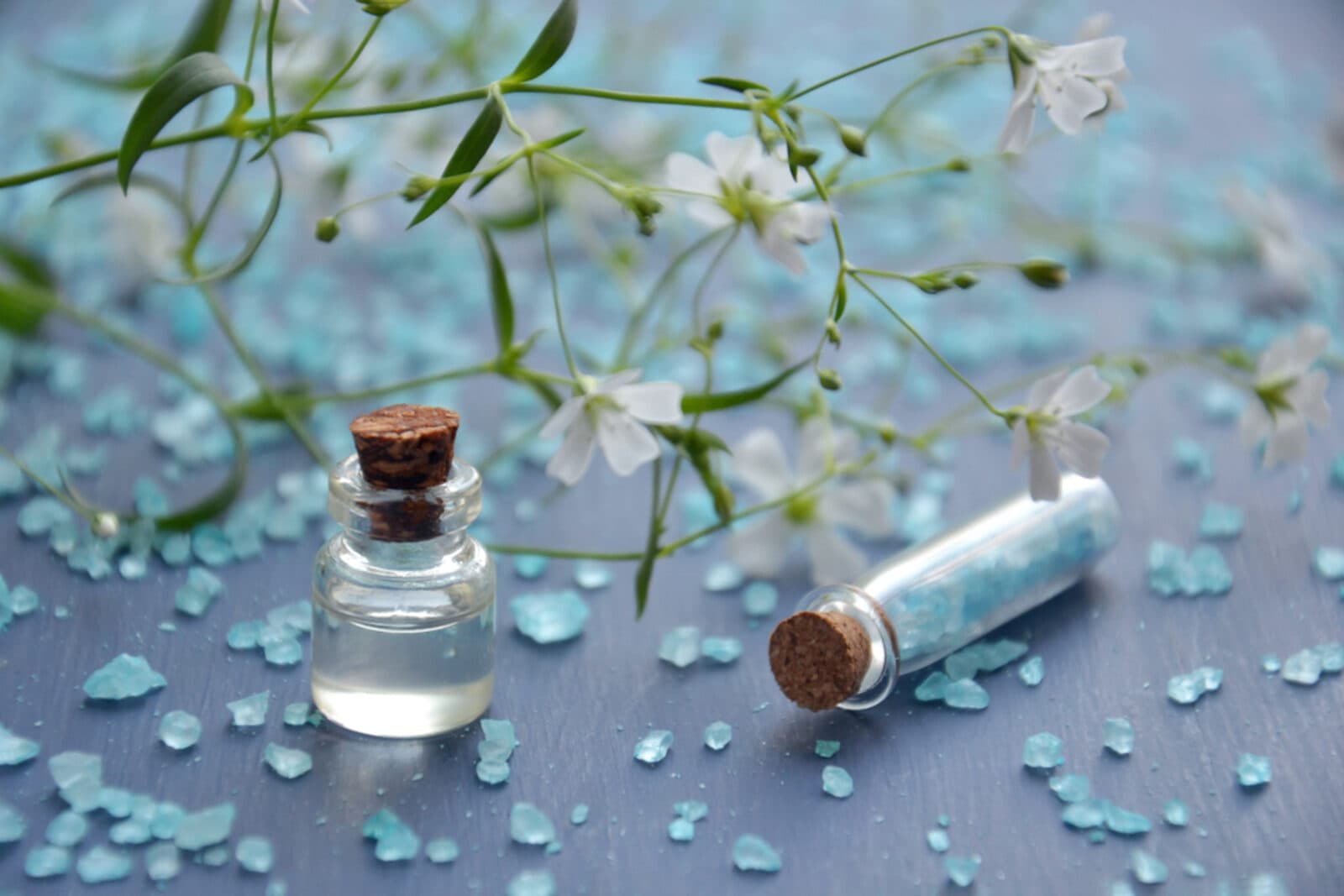 Essential oils and delicate flowers in soft light