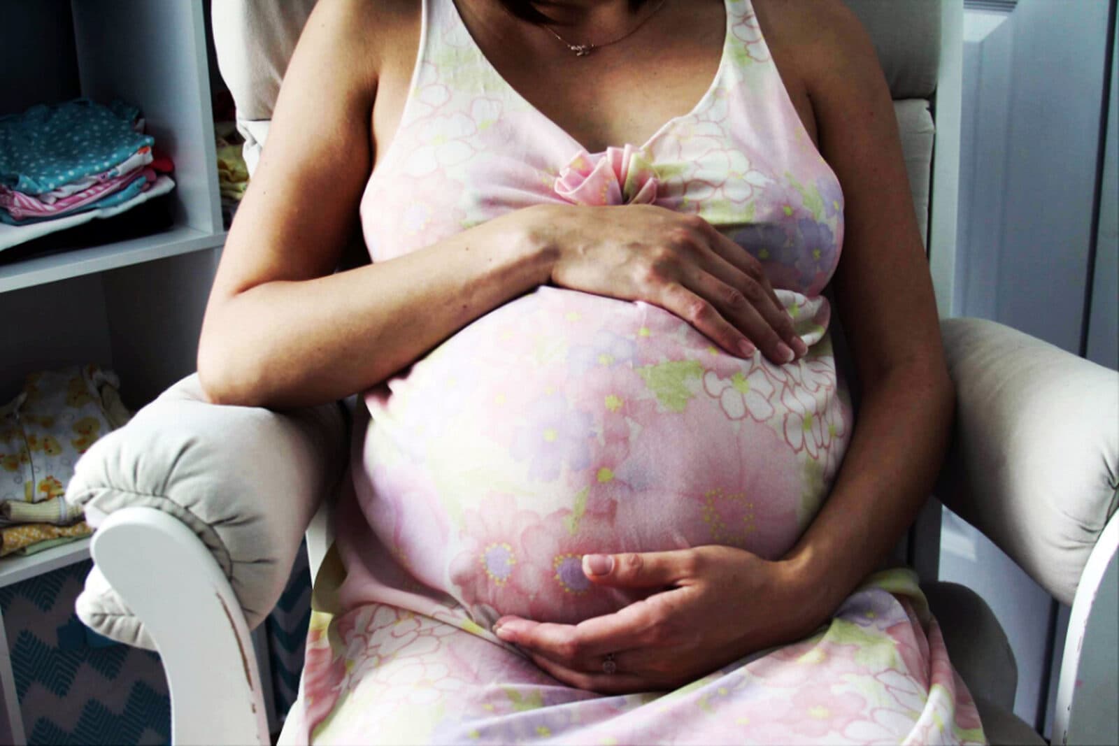 A pregnant woman resting calmly, a hand on her bump