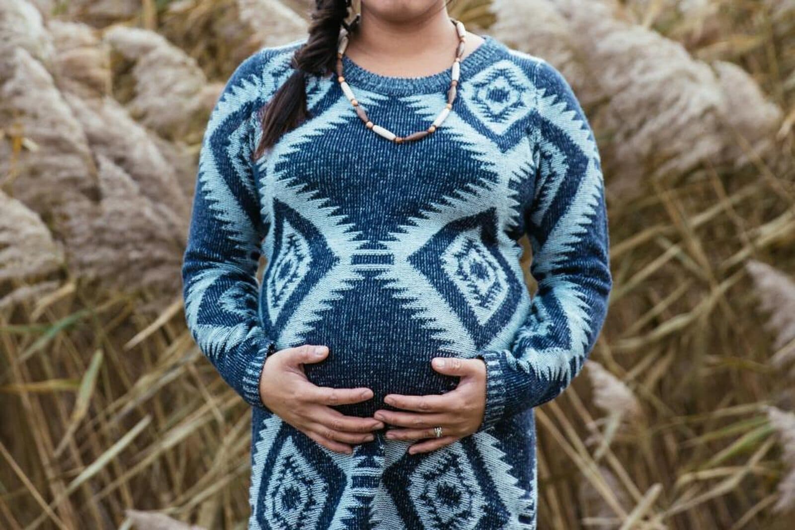 A pregnant woman cradling her bump, calm and warm